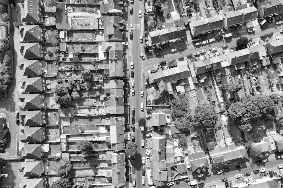 An aerial black-and-white photograph shows a residential property on Harvist Road during a house removal process. The house is a detached, two-storey building with a pitched roof and rooflights, situa